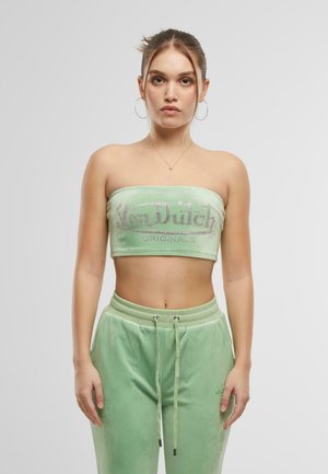 Zaļš samta bezsēžamais īsais tops ar uzrakstu "Von Dutch Originals" izšūtu ar rhinestones, apvienots ar atbilstošiem zaļiem samta sporta biksēm un šņorēšanu.