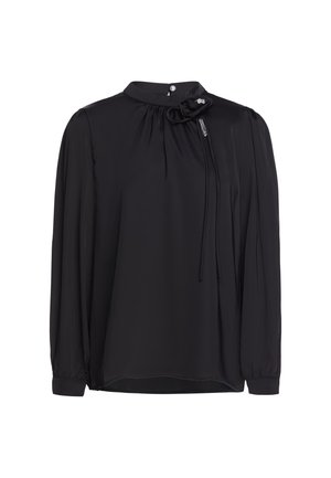 Blusa nera a maniche lunghe con collo alto, scollo arricciato, maniche con polsini e fiore decorativo con fili pendenti vicino al collo.