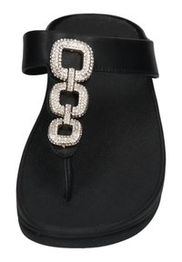 Zwarte flip-flop sandaal met een gestructureerde zool, voorzien van een glanzend zilveren kettingaccent versierd met rhinestones en een enkel bandontwerp.