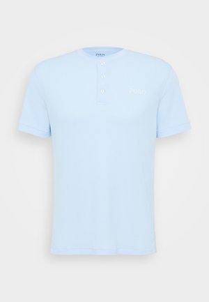 Svijetloplava polo majica kratkih rukava s rebrastom teksturom, plaketom na tri gumba i vezanim "POLO" logotipom na prsima.