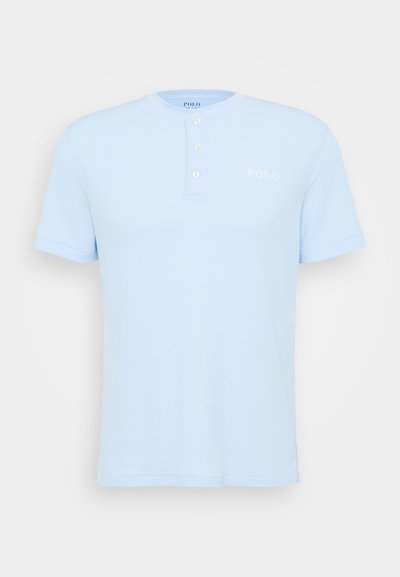 Šviesiai mėlynas trumpų rankovių polo marškinėliai su grioveliais, trijų mygtukų užsegimu ir siuvinėtu "POLO" logotipu ant krūtinės.