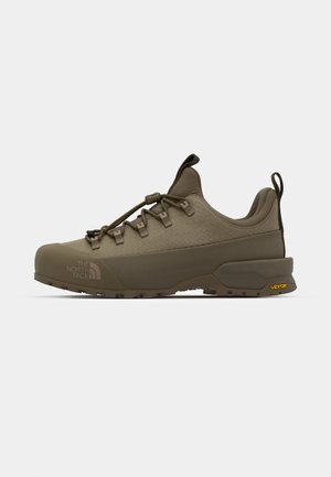 Brune tursko med en teksturert overdel, gummisåle, justerbare lisser og Vibram-merke på siden. Lett og slitesterk design.