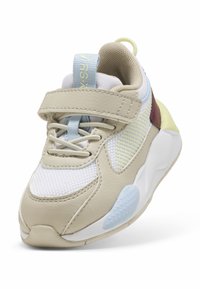 Scarpa atletica beige con materiali in rete e pelle, con accenti blu e gialli, cinturino regolabile e suola testurizzata.