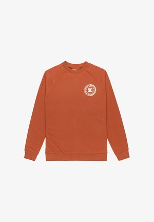 Rustfarvet sweatshirt med rund halsudskæring, raglanærmer og en cirkulær hvid logo på venstre brystområde. Blødt, tekstureret stof.
