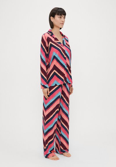 Farverig pyjamassæt i chevron-mønster med pink, blå og marine. Langærmet skjorte med krave, knaplukning foran og matchende brede bukser.