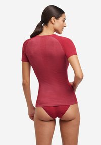Rood sporttop met korte mouwen van gestructureerde stof en een fitted ontwerp, gecombineerd met bijpassende low-rise bottoms.