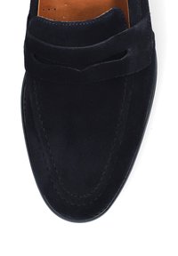 Granatowe zamszowe mokasyny o gładkiej fakturze, z dekoracyjnym wzorem wycięcia i kontrastowym przeszyciem. Okrągły czubek i elastyczna podeszwa.
