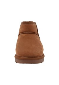 Braune Wildleder-Ankle-Boots mit weicher Textur, runder Zehenpartie und Gummisohle. Mit stikierten Akzenten entlang der oberen Naht.