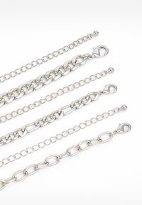 Cinci lanțuri de metal argintii cu modele și lungimi variate, fiecare având inele de forme și mărimi diferite, cu un închizător la un capăt.
