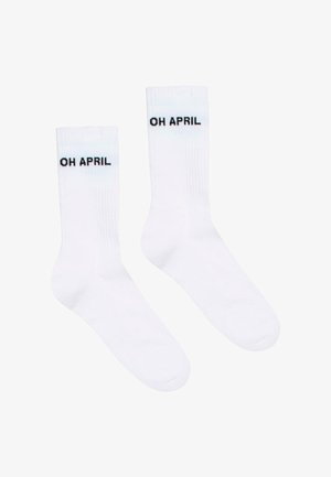 Hvide bomuldsstrømper med sorte bogstaver "OH APRIL" på ribbenet. Glat tekstur, standard sokkeform, egnet til afslappet brug.