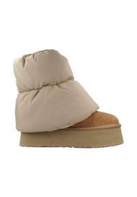 Botín de tobillo beige, acolchado, con un exterior suave, puntera de ante y una suela gruesa de plataforma. El diseño presenta detalles gathered en la parte superior.