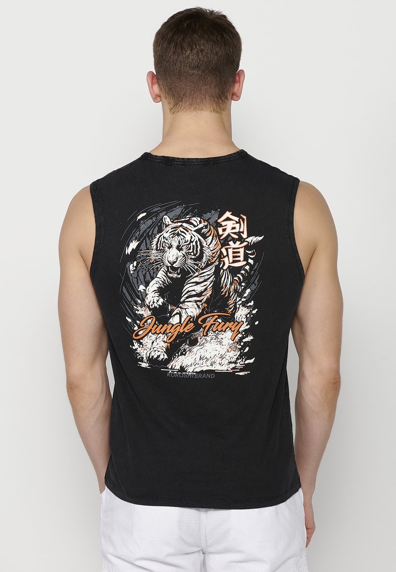 Crna majica bez rukava s grafikom tigra i natpisom "Jungle Fury" u narančastoj i bijeloj boji, izrađena od pamuka s ležernim krojem.