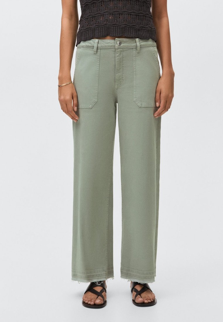 Ljust gröna vida byxor i bomull, med två framfickor, fransad fåll och knappstängning. Matchas med svarta sandaler.