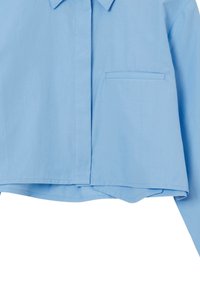 Camicia corta azzurro chiaro realizzata in tessuto morbido, con colletto, taschino sul petto sinistro e orlo dritto.