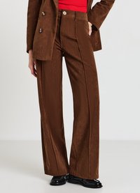 Braune Cordhose mit weitem Bein und hoher Taille, mit vertikalen Rippungen, einem vorderen Knopfverschluss und einer glatten, strukturierten Oberfläche.