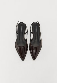 Spisse tå slingback-sko i glatt mørkebrun patentert lær. Har en tynn ankelrem og en strømlinjeformet silhuett med en glatt overflate.