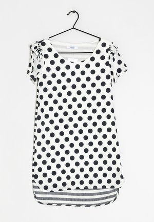 Haut à manches courtes à pois noirs et blancs avec encolure arrondie et détails froncés aux manches ; ourlet asymétrique avec revers rayé.