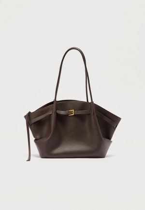 Σκούρο καφέ δερμάτινη τσάντα tote με μακριές λαβές, λεπτομέρεια από χρυσή αγκράφα στο μπροστινό λουρί και ελαφρώς χαλαρή μορφή.