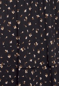Zwarte stof met een bloemenpatroon dat kleine witte en bruine bloemen bevat. Het ontwerp omvat gelaagde secties met een zachte textuur.