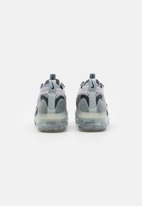 Nike VaporMax-sneakers med en grå mesh-övre del, mörka accenter och en transparent luft-sula med färgglada prickar.