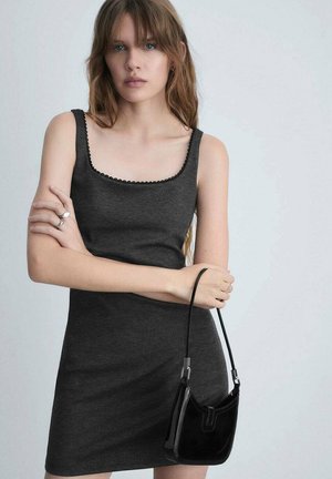Gray sleeveless dress with a square neckline and scalloped trim, paired with a small black velvet handbag featuring a thin strap.