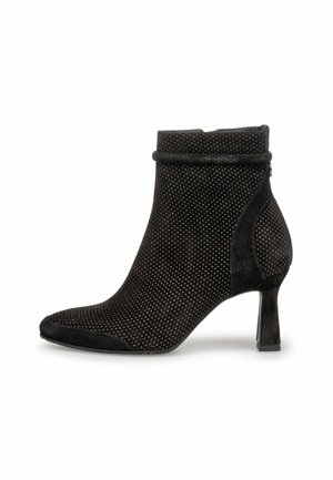 Stivale alla caviglia in suede nero con punta appuntita, tacco basso e texture a pois. Presenta un colletto liscio e dettagli decorativi.
