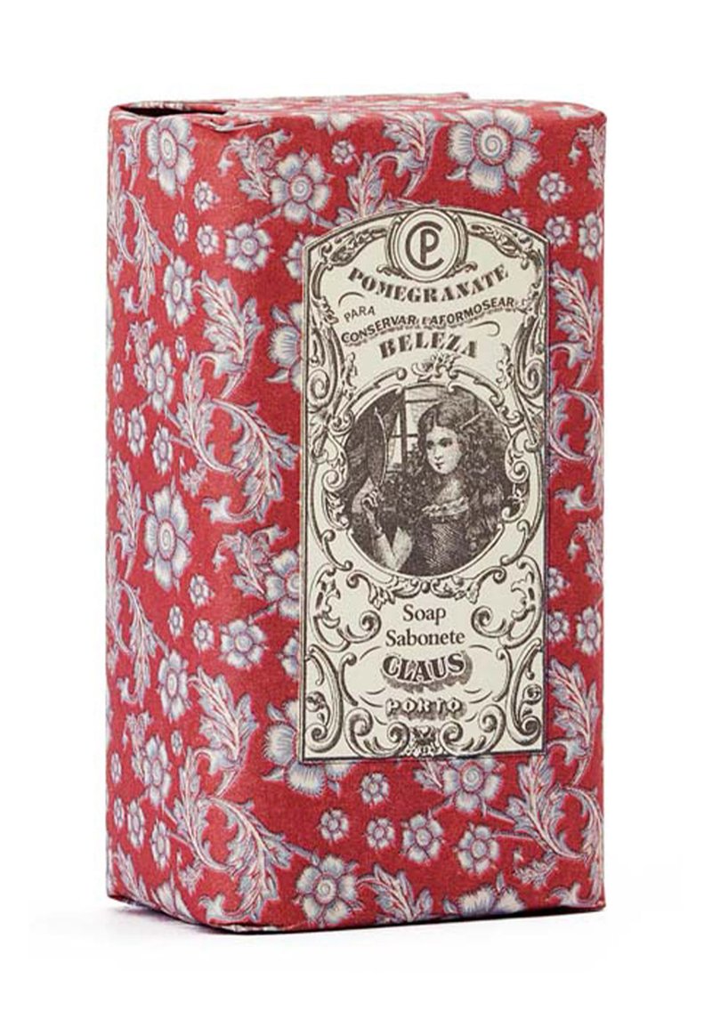 Red floral-patterned box, featuring a vintage label with an illustration. Text reads “Pomegranate Soap” and “Claus Porto.” Textured paper surface.