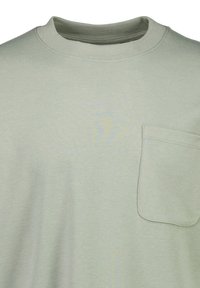 Ljusgrön bomulls t-shirt med rund hals, korta ärmar och en framficka. Tyget har en slät, något strukturerad yta.