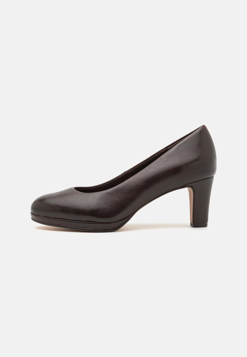 Escarpin en cuir marron foncé à talon moyen, bout rond et semelle plateforme basse sur un fond clair uni.