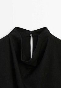 Black blouse featuring a high neckline, keyhole back opening, and two black buttons for closure. Made of lightweight textured fabric.
