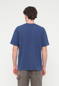 Σκούρο μπλε βαμβακερό T-shirt με στρογγυλή λαιμόκοψη, κοντά μανίκια και άνετη εφαρμογή. Επίπεδες ραφές και ομαλή υφή· χωρίς ορατά γραφικά.