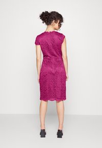 Vestido de renda ajustado em magenta profundo, com mangas curtas, padrão floral, bainha em scallop e detalhe de cintura franzida.