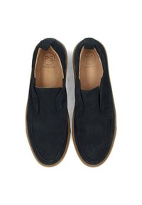 Zapatos negros de ante tipo slip-on con forro de cuero suave y suela de goma. Presentan puntera redondeada y detalles de costura mínimos.