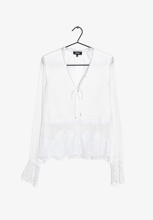 Witte blouse met lange mouwen en kanten afwerking aan de manchetten en zoom, V-hals met strikdetail, hangend aan een zwarte hanger tegen een witte achtergrond.