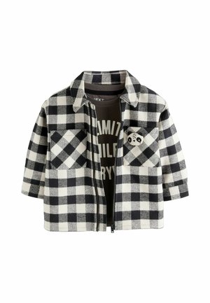 Veste à carreaux noir et blanc avec manches courtes, fermeture éclair, deux poches avant et un accent panda sur la poche gauche.