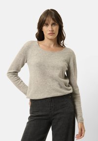 Maglione grigio chiaro a maniche lunghe realizzato in un morbido misto lana, con scollatura a barchetta e vestibilità comoda. Abbinato a jeans neri.
