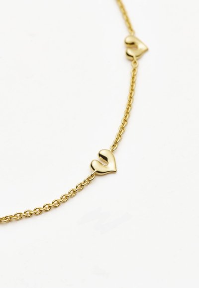Χρυσό κολιέ με αλυσίδα που διαθέτει δύο μικρούς αφηρημένους κρίκους σε σχήμα καρδιάς σε λευκό φόντο.