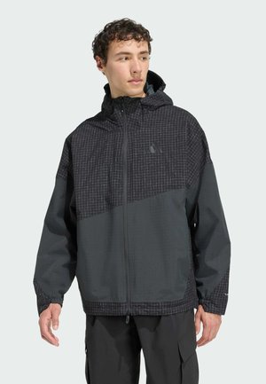 Schwarze Jacke mit mehreren Paneelen und Karomuster, mit Kapuze, elastischen Bündchen und Frontreißverschluss. Hergestellt aus leichtem, wasserabweisendem Material.