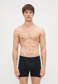 Boxerii negri, ajustați, cu talie elastică. Realizați dintr-un material moale și elastic, concepuți pentru confort, cu cusături minime.