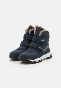 Marineblaue Wanderschuhe mit zwei verstellbaren Klettverschlüssen, gefälschter Fellinnensohle, Gore-Tex-Label und robustem schwarzen Gummisohle.