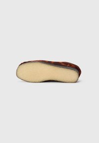 Brown leather slipper with a soft beige fur lining, flat sole, and curved design. Features a smooth exterior and textured underside.