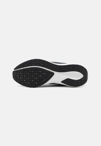 Schwarze Gummisohle mit strukturiertem Muster; weiße Zwischensohle. Das Obermaterial besteht aus Mesh und synthetischem Material und zeigt ein schlankes Design.