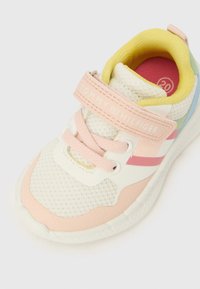 Pantof sport ușor, din plasă albă, cu accente roz, albastre și galbene. Dispune de o curea roz cu velcro și talpă texturată pentru aderență.