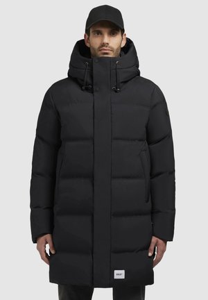 Black puffer coat featuring a hood, snap buttons, and side pockets. Thick quilted design with a textured surface. Brand label visible.