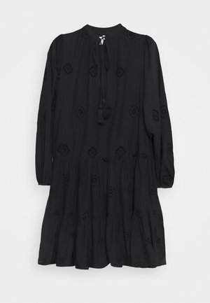 Μαύρο φόρεμα από ελαφρύ ύφασμα, με μακριά μανίκια, στρογγυλή λαιμόκοψη, φουστάνι με επίπεδες ρίγες και διακοσμητικές τρύπες με φούντες.