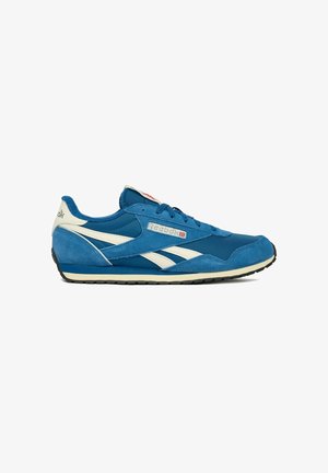 Blauer und weißer Reebok-Sneaker mit Velours- und Stoffpaneelen, Schnürdesign und schwarzer Gummisohle, seitlich dargestellt.