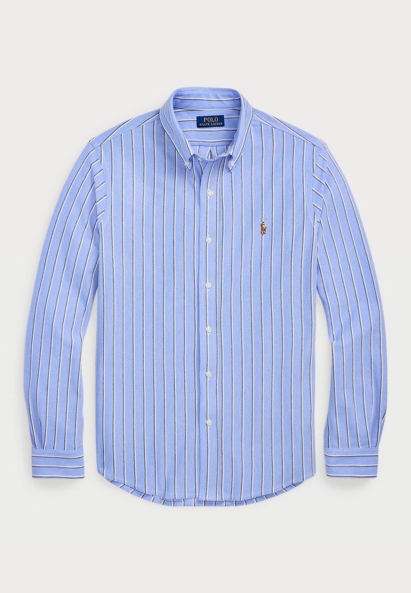 Šviesiai mėlynas mygtukais užsegamas marškinis su vertikaliomis baltomis ir tamsiai mėlynomis juostelėmis, apykakle, ilgomis rankovėmis ir mažu siuvinėtu logotipu ant krūtinės.