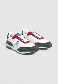 Zapatillas con parte superior de malla blanca, acentos de ante burdeos, suela de goma verde y detalle del logo. Cuenta con cordones redondos y cuello acolchado.