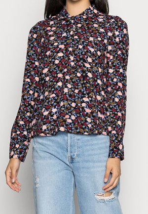 Blouse à manches longues avec un fond noir, ornée d'un motif floral en rose, rouge et bleu. Tissu léger, coupe décontractée, design à col.