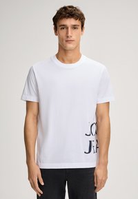 Weißes Baumwoll-T-Shirt mit Rundhalsausschnitt und kurzen Ärmeln, versehen mit einem grafischen Design in Dunkelblau auf der linken Seite.